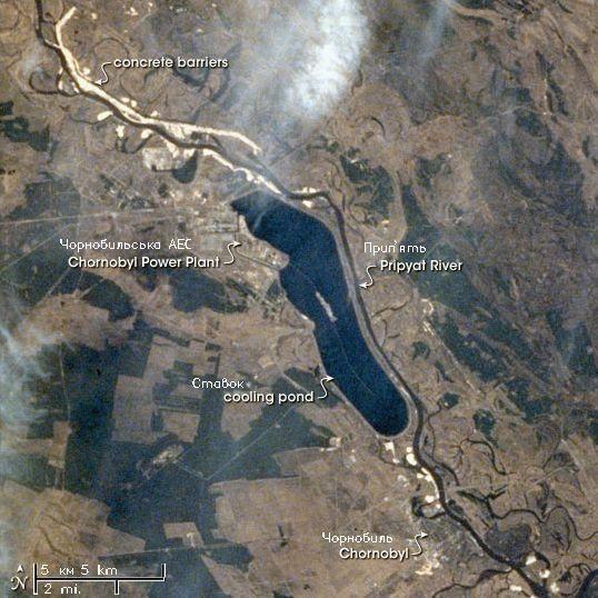 Satellite view of the Chernobyl Nuclear Power Plant showing the New Safe Confinement over Reactor 4. However, the true persistent hazards are the micro-particles scattered across the exclusion zone that have yet to decay physically. Source: Wikimedia Commons